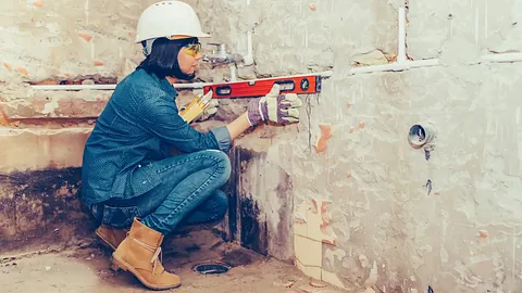 trabajadora de la construccion mide nivel